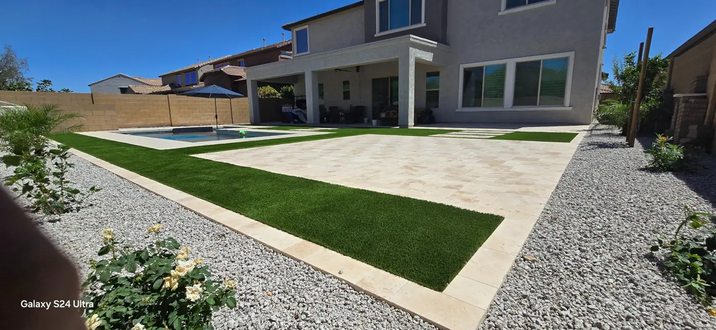 Travertine patio and turf layout beside the pool by L & R